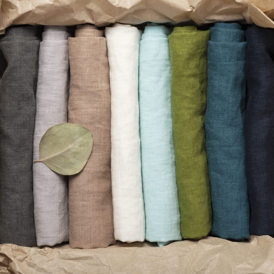 Set of natural linen napkins on the light background, textile concept